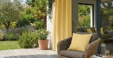 Elegáns UV-álló teraszfüggöny és kültéri párnák egy modern teraszon