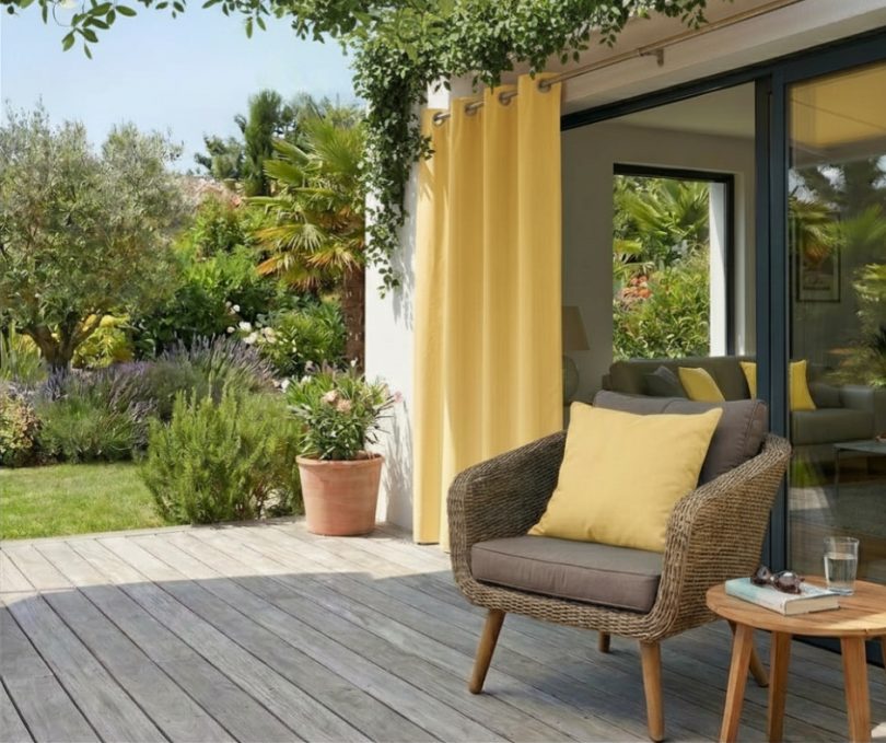 Elegáns UV-álló teraszfüggöny és kültéri párnák egy modern teraszon